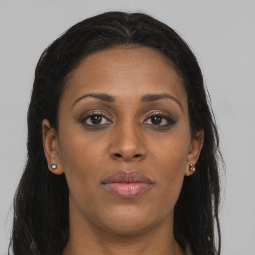 Joyful black young-adult female with long  brown hair and brown eyes