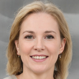 Joyful white adult female with medium  brown hair and grey eyes