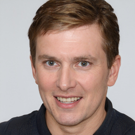 Joyful white adult male with short  brown hair and grey eyes