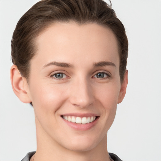 Joyful white young-adult female with short  brown hair and grey eyes