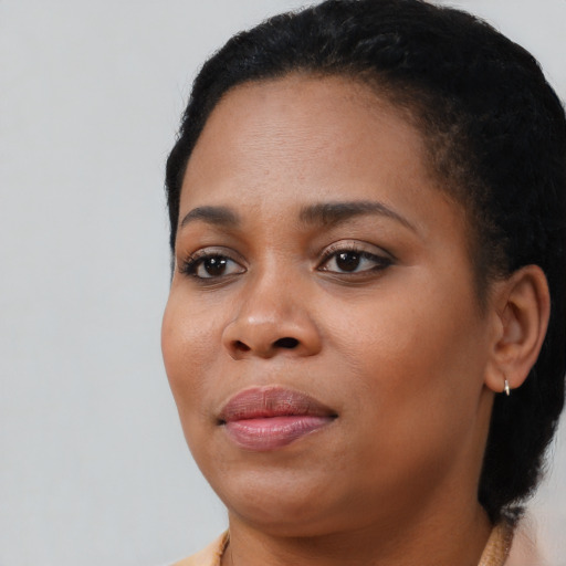 Joyful black young-adult female with short  black hair and brown eyes