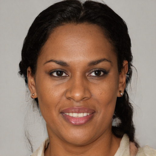 Joyful black adult female with medium  brown hair and brown eyes