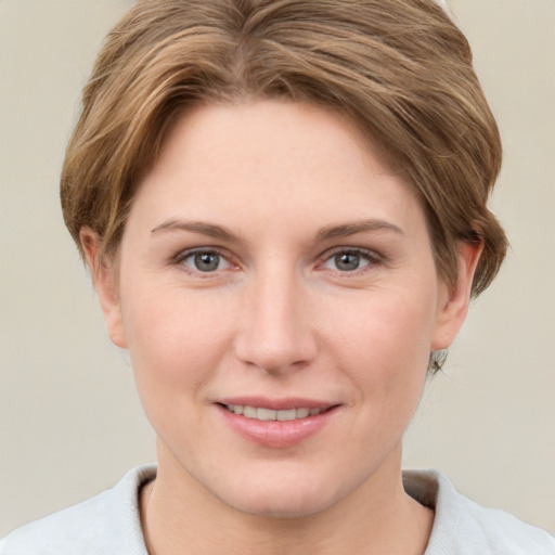 Joyful white young-adult female with short  brown hair and grey eyes