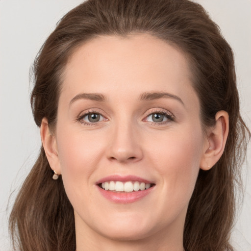 Joyful white young-adult female with long  brown hair and grey eyes