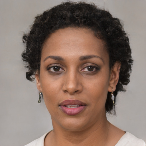 Joyful black young-adult female with short  black hair and brown eyes