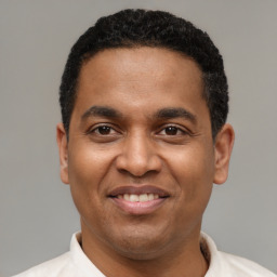 Joyful latino young-adult male with short  black hair and brown eyes