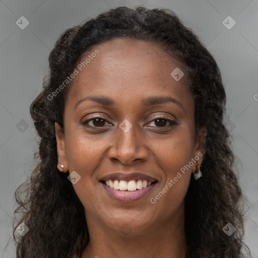 Joyful black young-adult female with long  brown hair and brown eyes