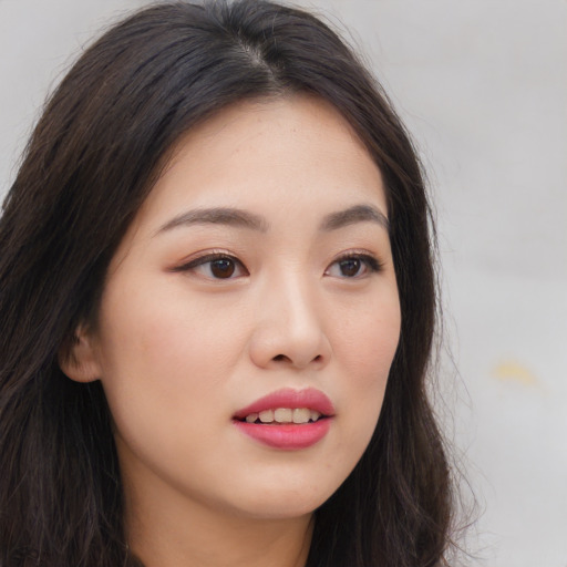 Joyful asian young-adult female with long  brown hair and brown eyes