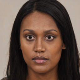 Joyful black young-adult female with long  brown hair and brown eyes