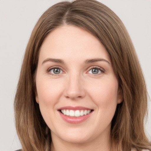 Joyful white young-adult female with long  brown hair and grey eyes