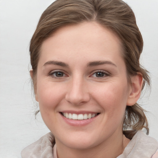 Joyful white young-adult female with medium  brown hair and grey eyes