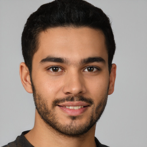 Joyful latino young-adult male with short  brown hair and brown eyes