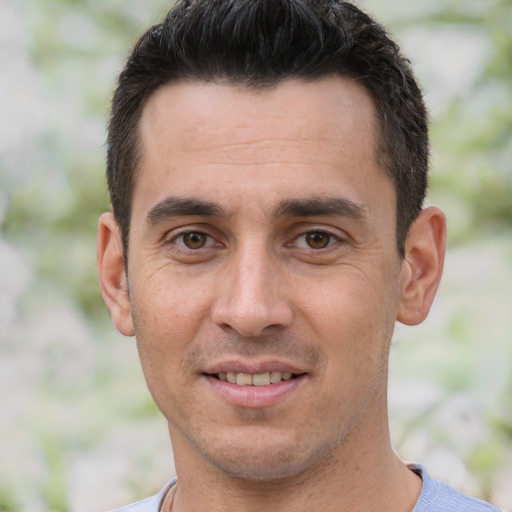 Joyful white adult male with short  black hair and brown eyes