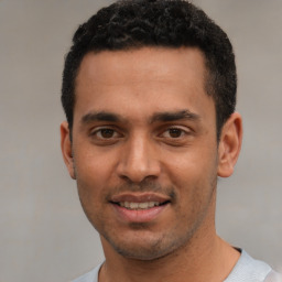 Joyful white young-adult male with short  black hair and brown eyes