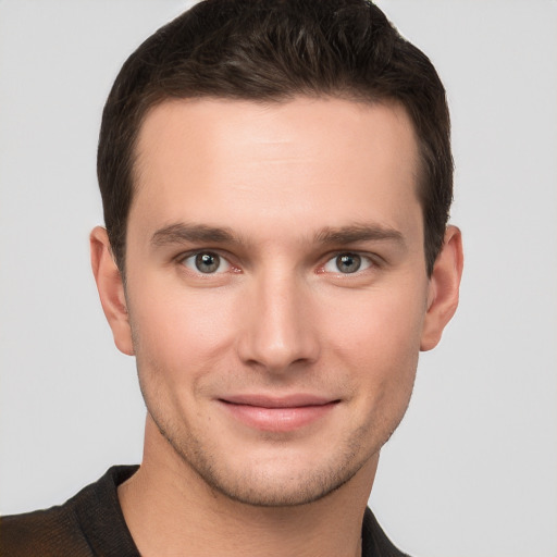 Joyful white young-adult male with short  brown hair and grey eyes