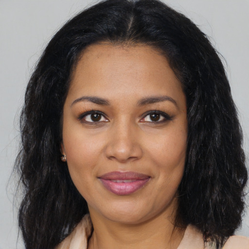 Joyful black young-adult female with long  black hair and brown eyes
