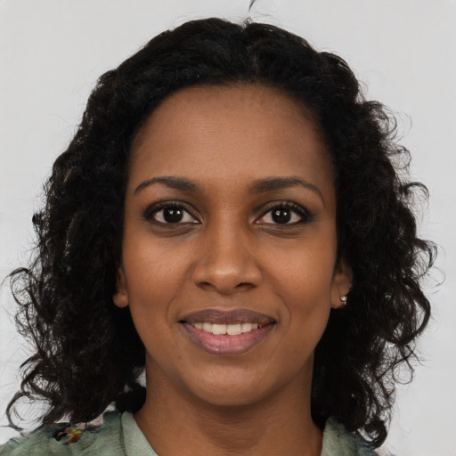 Joyful black young-adult female with medium  black hair and brown eyes