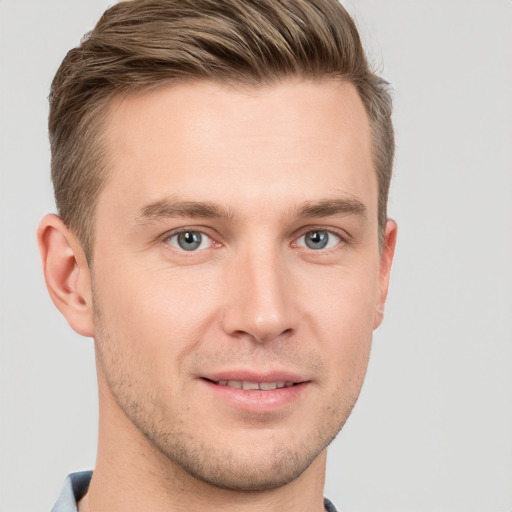 Joyful white young-adult male with short  brown hair and grey eyes