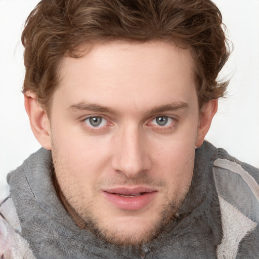 Joyful white young-adult male with short  brown hair and blue eyes