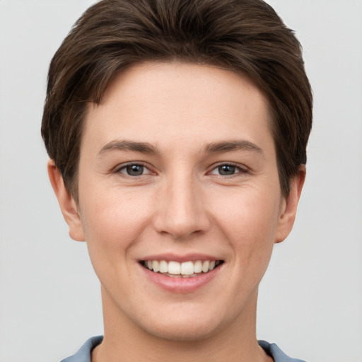 Joyful white young-adult female with short  brown hair and grey eyes