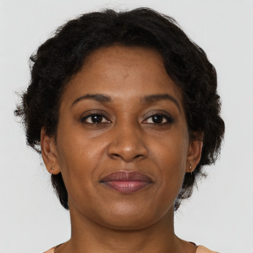 Joyful black adult female with short  brown hair and brown eyes