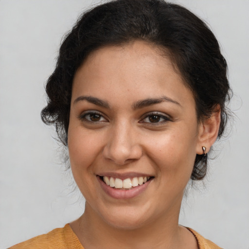 Joyful latino young-adult female with medium  brown hair and brown eyes