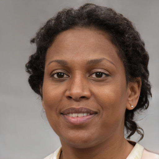Joyful black adult female with medium  brown hair and brown eyes