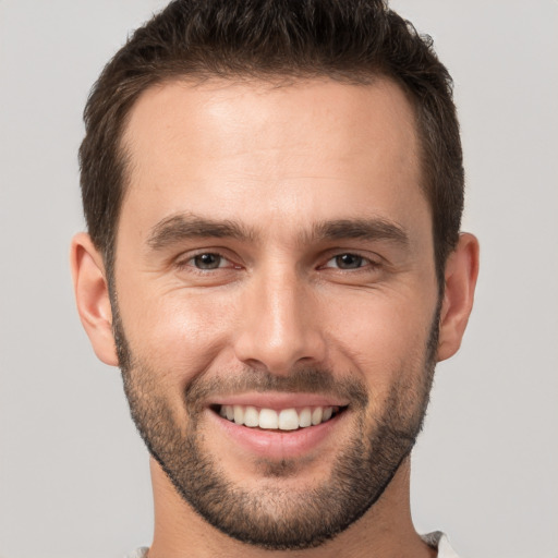 Joyful white young-adult male with short  brown hair and brown eyes