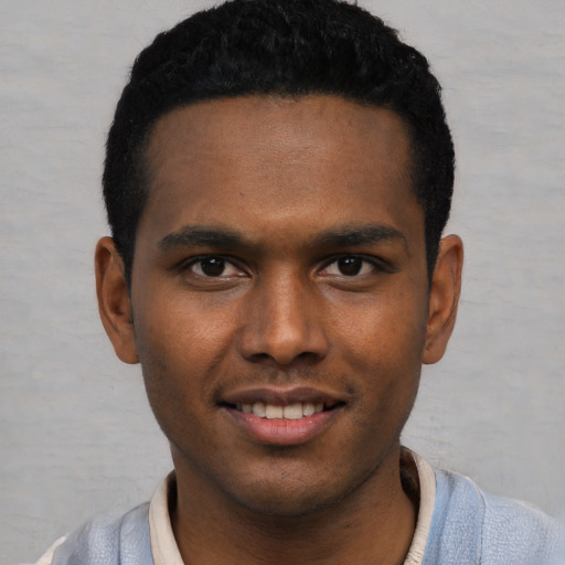 Joyful black young-adult male with short  black hair and brown eyes