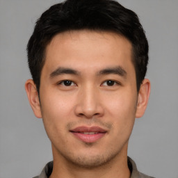 Joyful asian young-adult male with short  brown hair and brown eyes