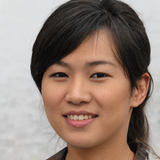 Joyful asian young-adult female with medium  brown hair and brown eyes