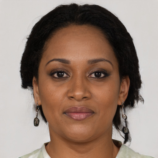 Joyful black adult female with short  brown hair and brown eyes