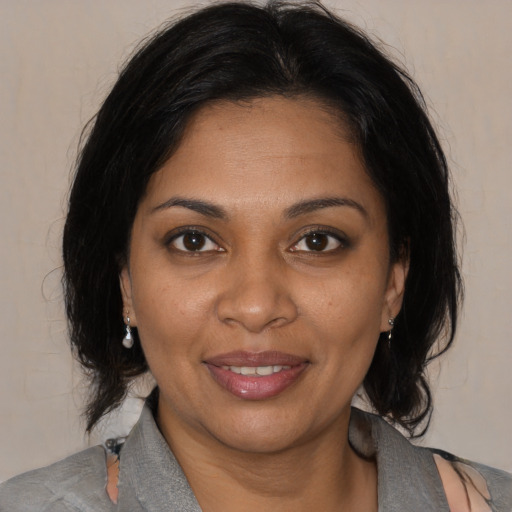 Joyful black adult female with medium  black hair and brown eyes