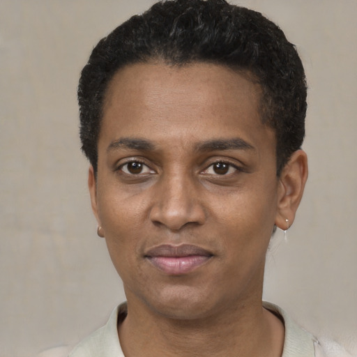 Joyful black young-adult male with short  black hair and brown eyes