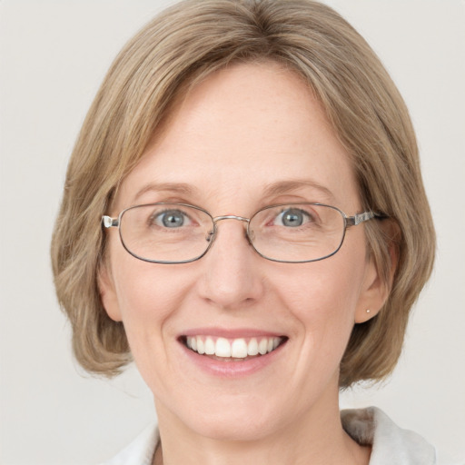 Joyful white adult female with medium  brown hair and blue eyes