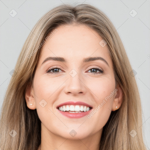 Joyful white young-adult female with long  brown hair and brown eyes