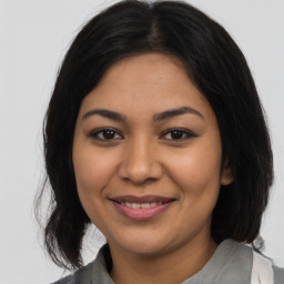 Joyful latino young-adult female with medium  brown hair and brown eyes