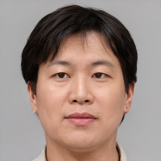Joyful asian adult male with short  brown hair and brown eyes
