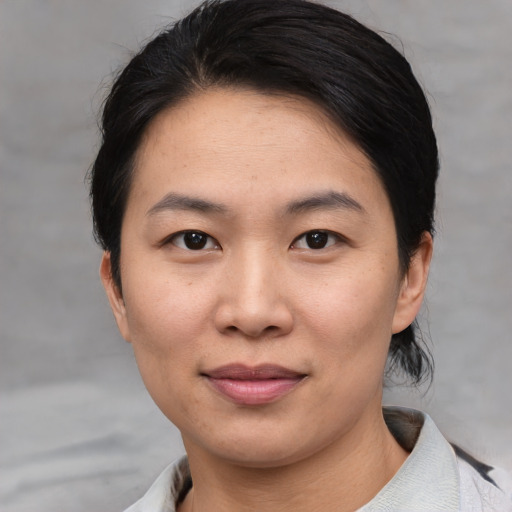 Joyful asian young-adult female with medium  brown hair and brown eyes