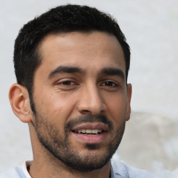 Joyful white young-adult male with short  black hair and brown eyes