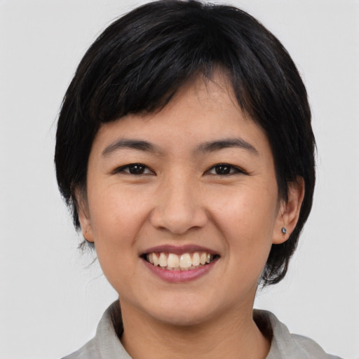 Joyful asian young-adult female with medium  black hair and brown eyes
