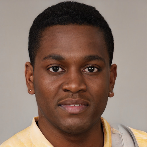 Joyful black young-adult male with short  brown hair and brown eyes