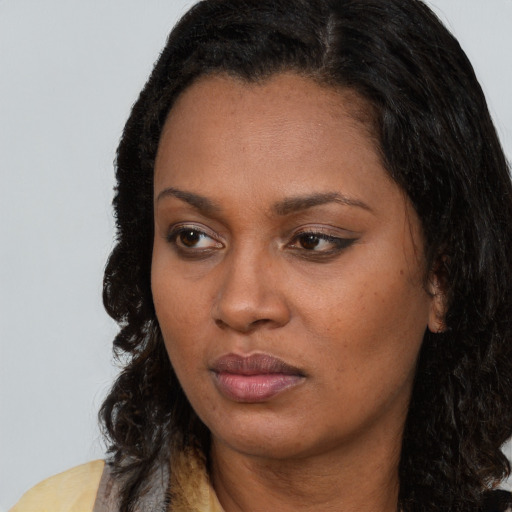 Neutral black young-adult female with long  brown hair and brown eyes