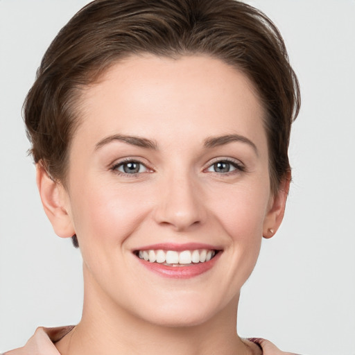 Joyful white young-adult female with short  brown hair and grey eyes