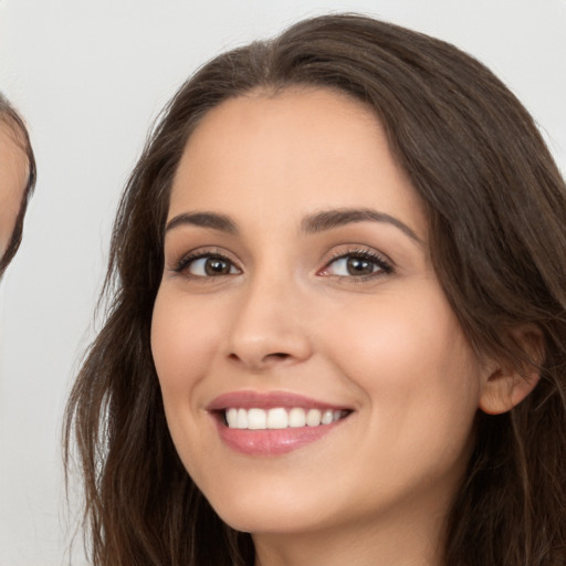 Joyful white young-adult female with long  brown hair and brown eyes