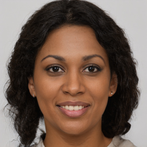 Joyful black young-adult female with medium  brown hair and brown eyes