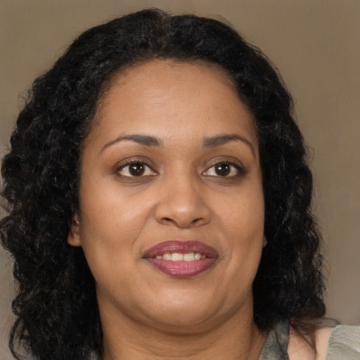 Joyful black adult female with long  brown hair and brown eyes