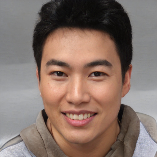 Joyful asian young-adult male with short  black hair and brown eyes
