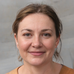 Joyful white adult female with medium  brown hair and grey eyes