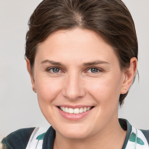 Joyful white young-adult female with medium  brown hair and grey eyes